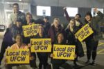 Smiling Cresco Labs workers hold Local 881 signs